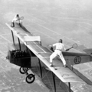 daredevils playing tennis on a biplane