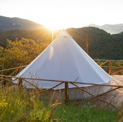 glamping tent on platform overlooking mountains with sun peaking out