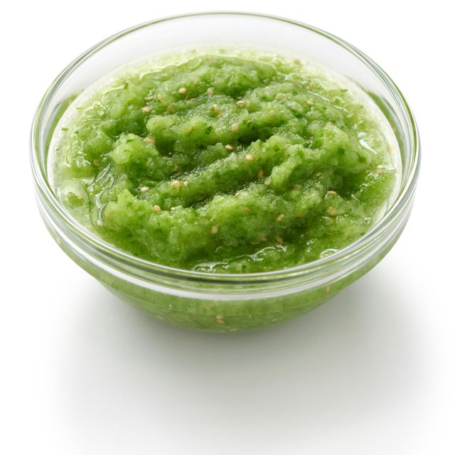 glass bowl of tomatillo salsa verde on a white background