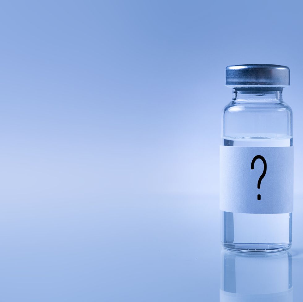 a glass medical bottle with a question mark on the label an ampoule with a vaccine for covid 19 or for colds and flu on a white background the concept of treatment and prevention of the spread of infection, virus and pneumonia