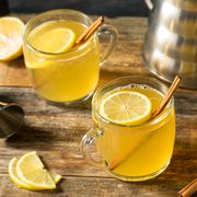 hot toddy in glass mug with lemon slices and cinnamon sticks