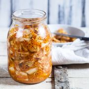 Glass of homemade Korean Kimchi with chinese cabbage, scallions and carrots