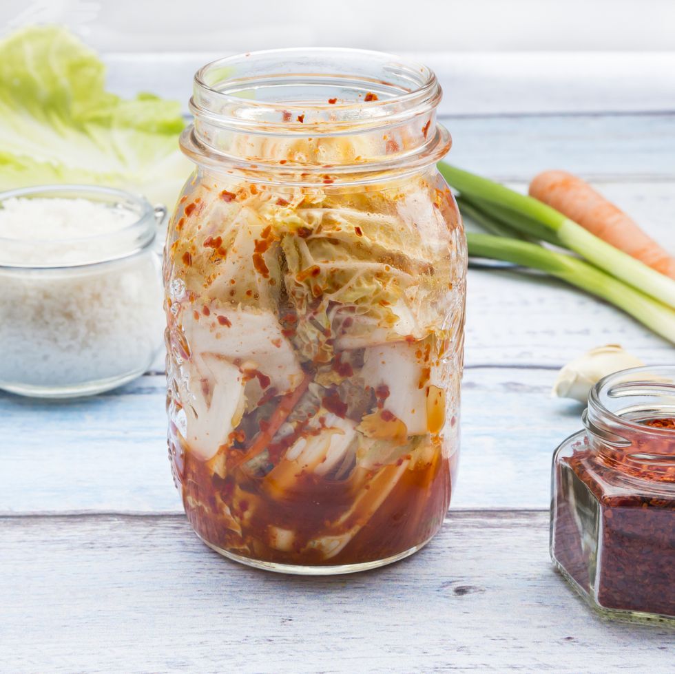 Glass of Kimchi and ingredients on wood