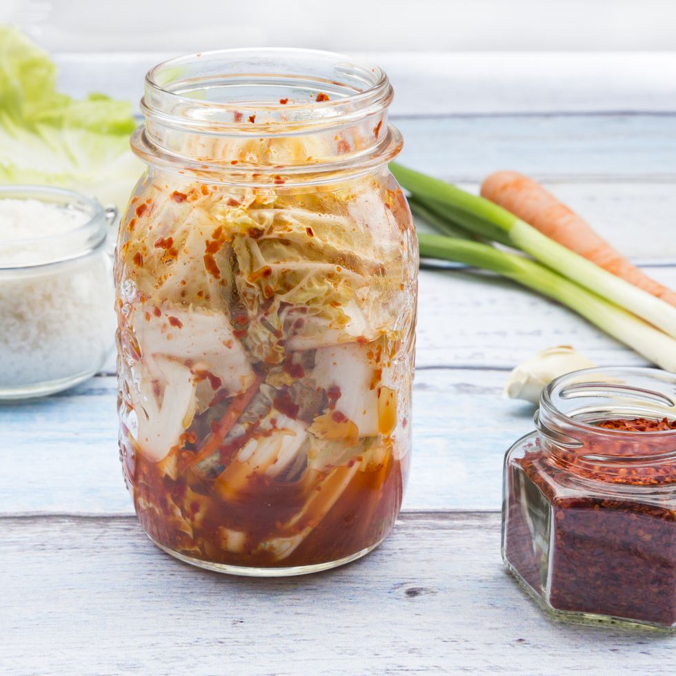 Glass of Kimchi and ingredients on wood