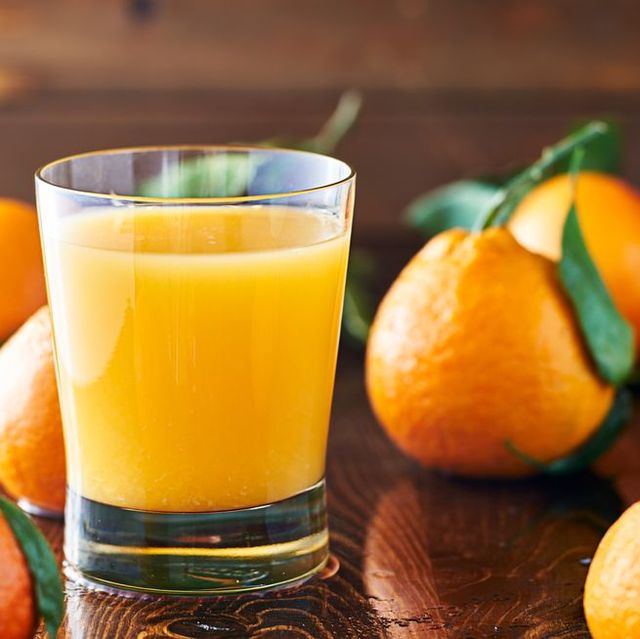 glass of orange juice with oranges