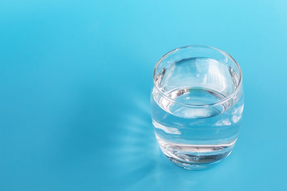 A glass of water on a blue background.