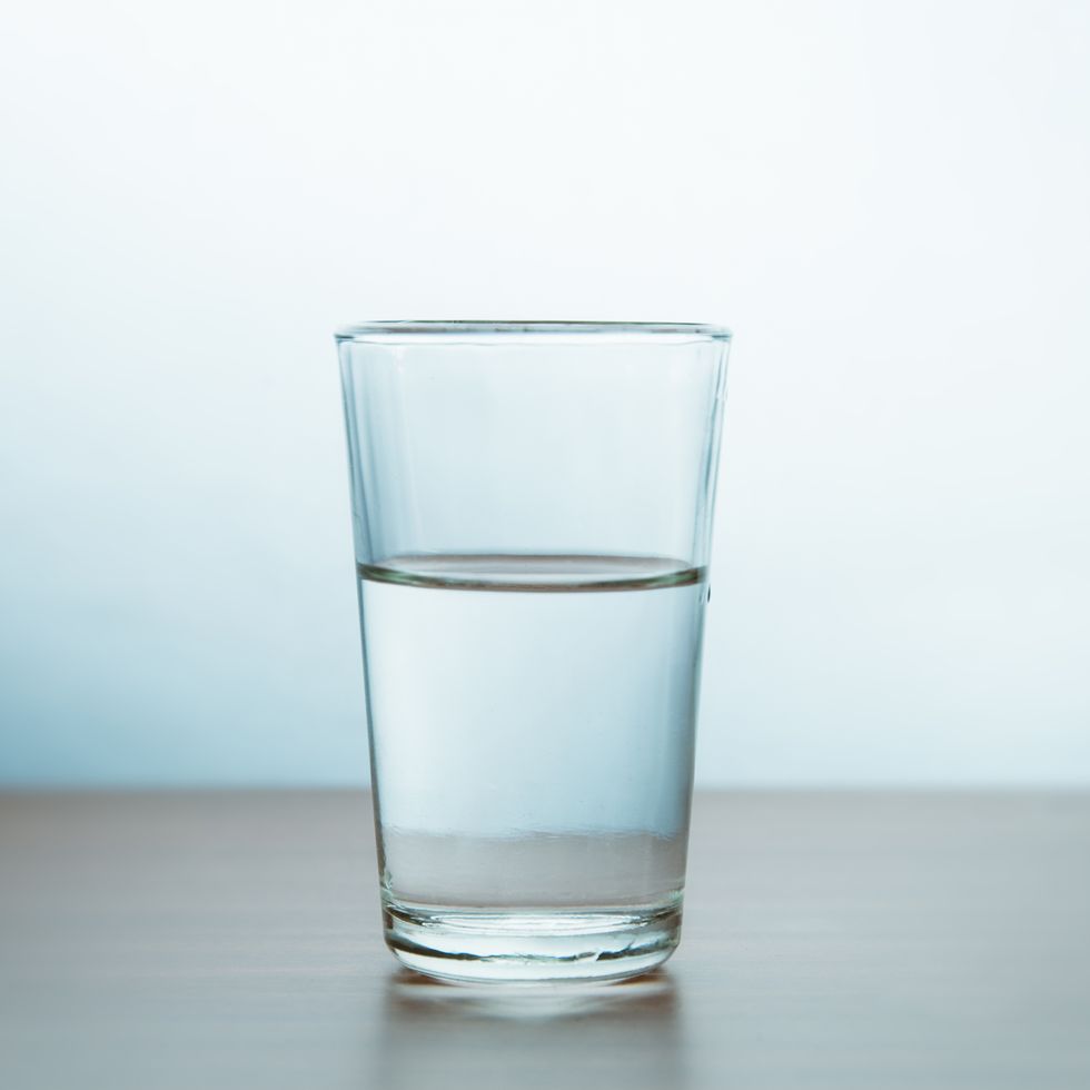 glass of water on table against wall