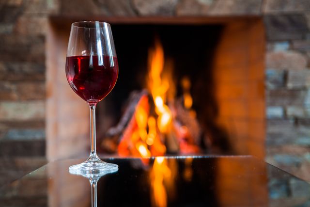 glass of wine near the fireplace in the evening