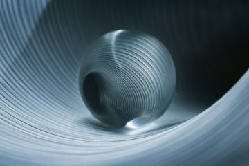 glass sphere in striped metal tube