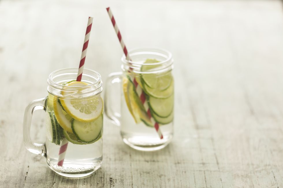 Glasses of infused water with lime, lemon, cucumber and ice cubes