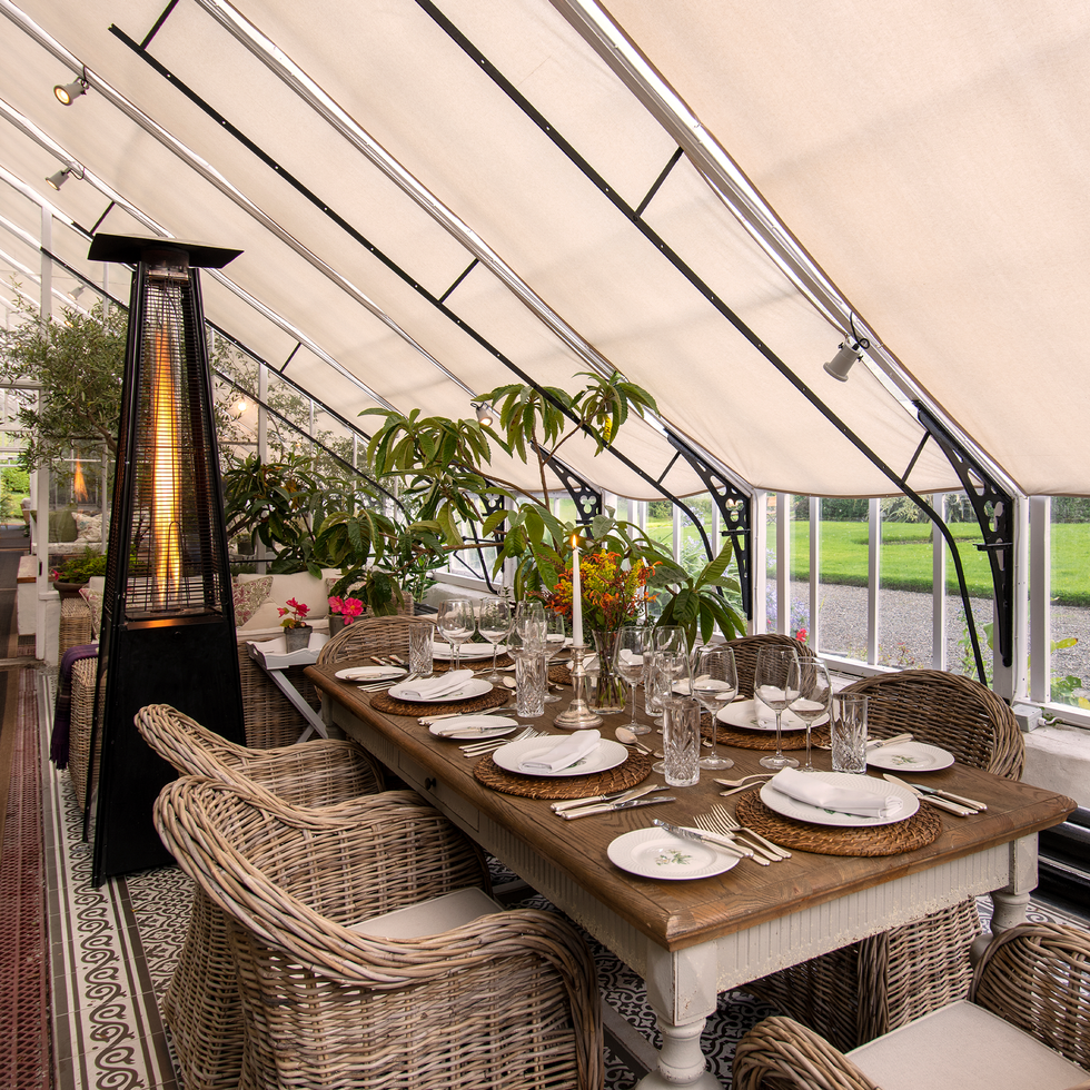 a table and rattan chairs in a conservatory