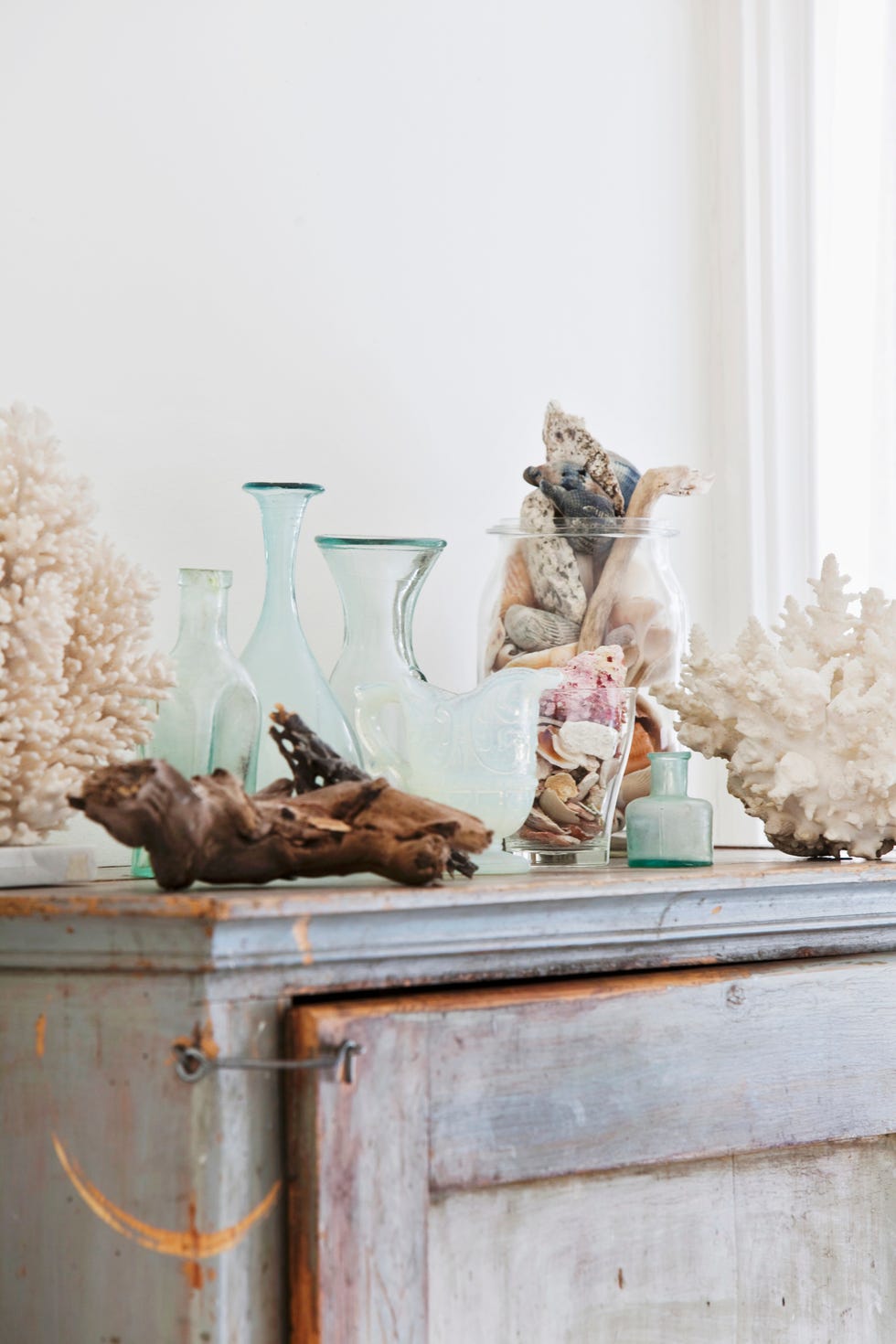 vases glass containers and flotsam on old cabinet in bathroom