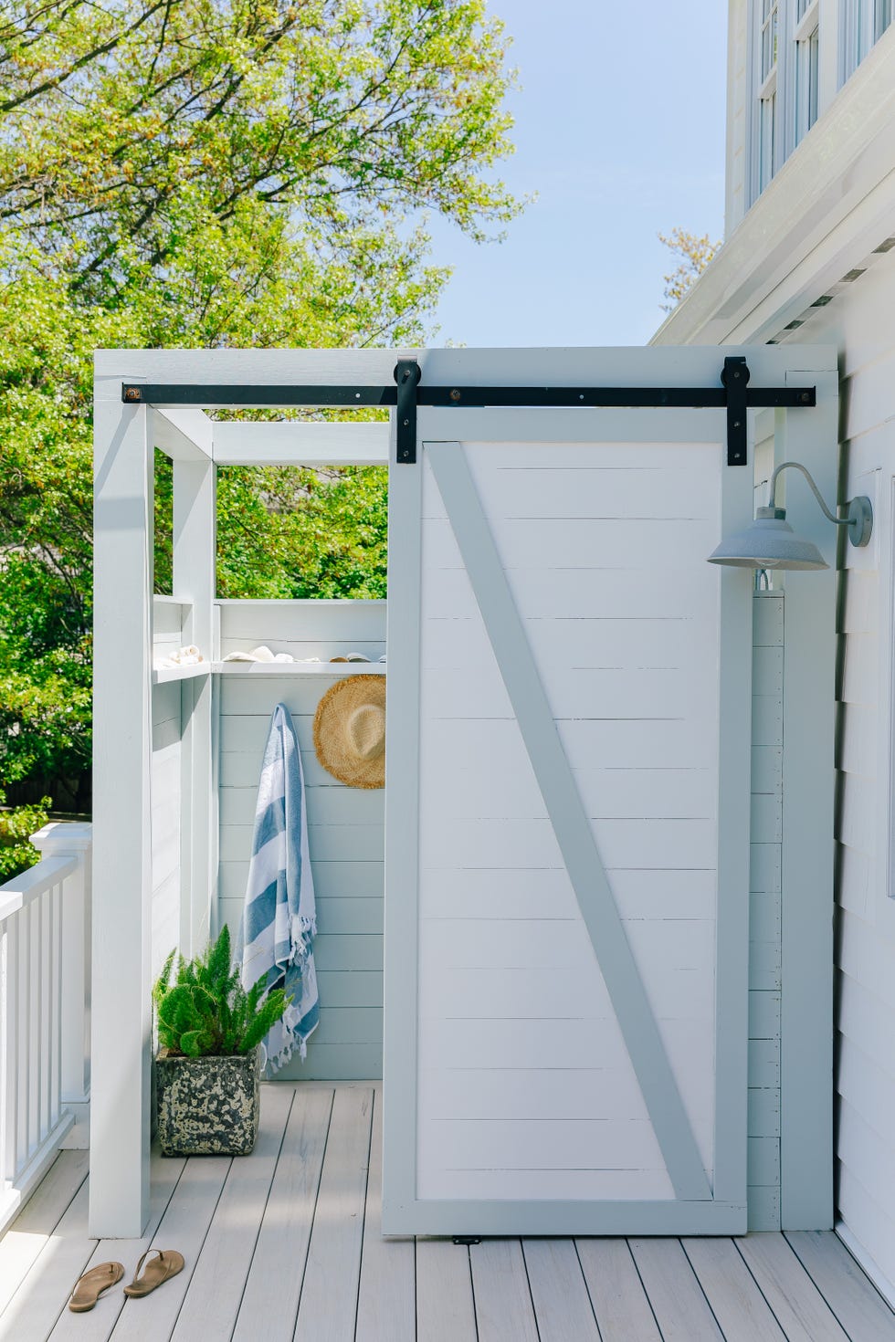 an outdoor shower with a sliding barn door