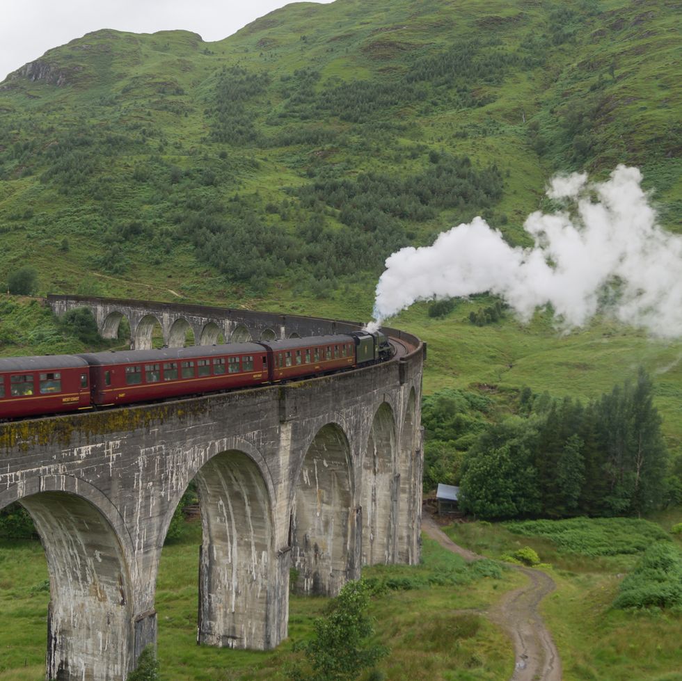 the jacobite steam train drives over the glenfinnen viaduct in scotland