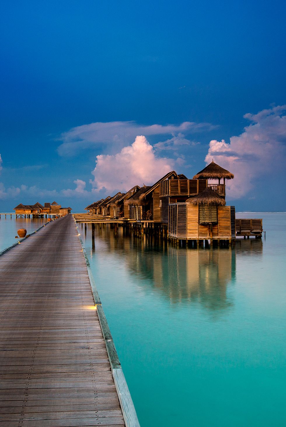 a dock leading to a building on a body of water