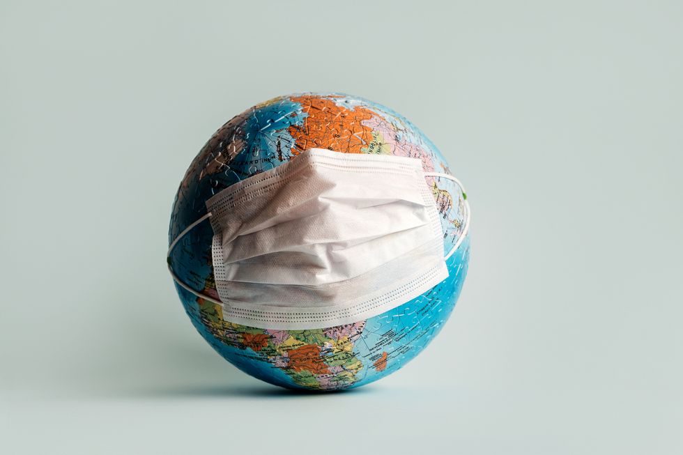 globe made of jigsaw puzzles with a protective medical mask