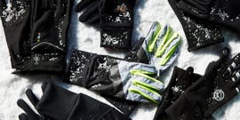 various gloves arranged on a snowy surface