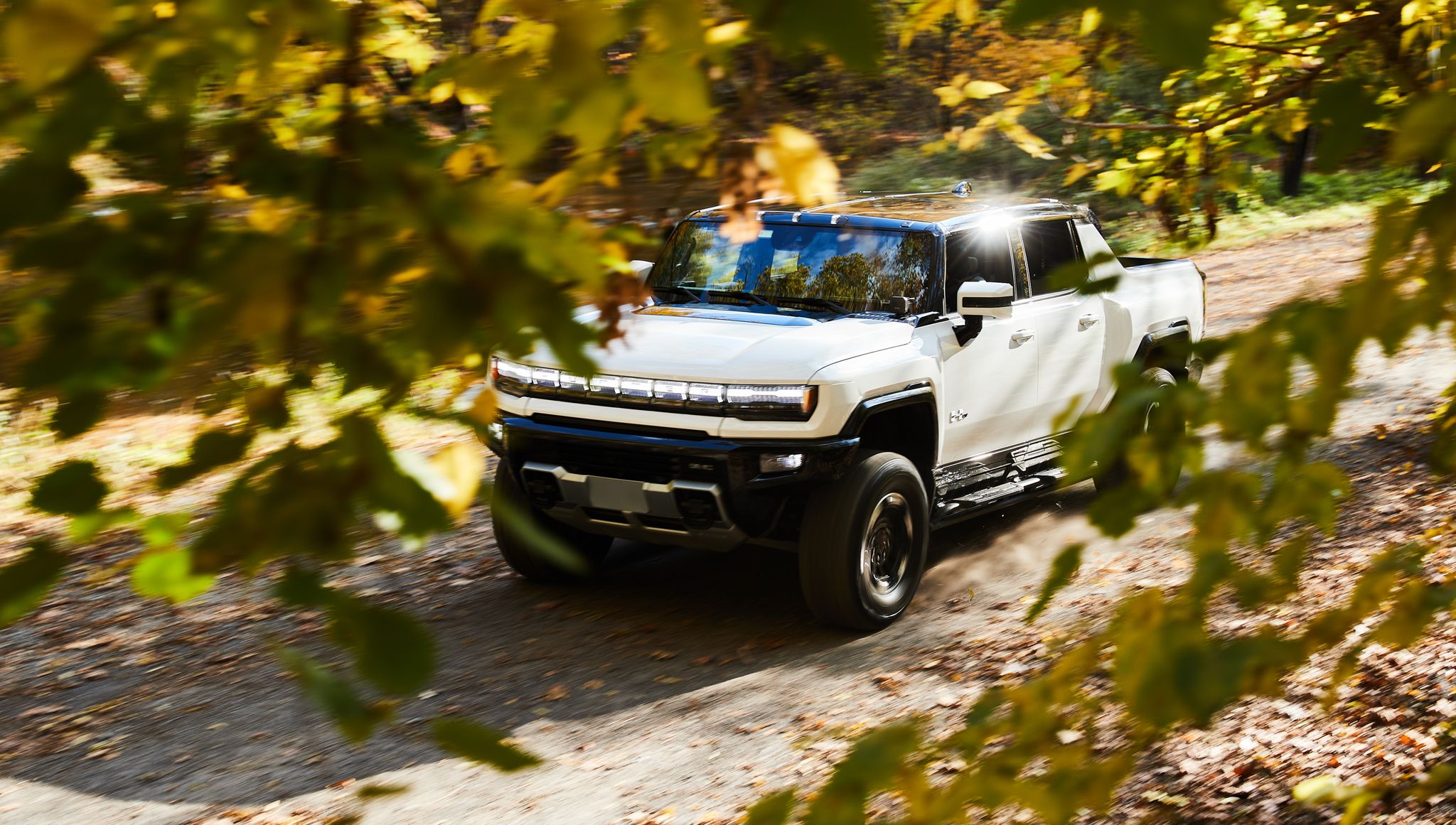 gmc hummer ev on country road in fall