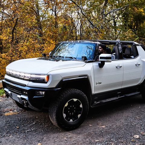 driving gmc hummer ev with roof panels off in woods