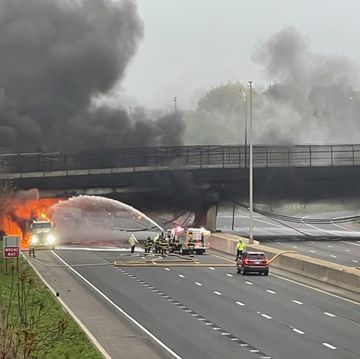 a car on fire on a road with smoke coming out of it