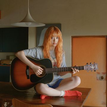 a person sitting on a table playing a guitar
