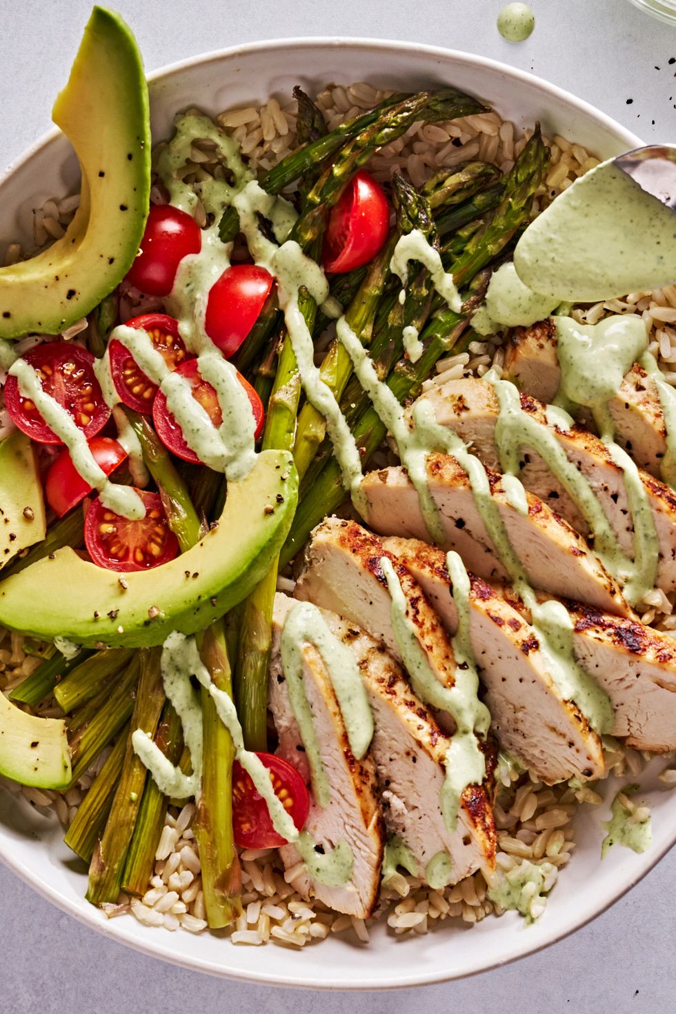 goddess bowls with chicken, asparagus, avocado and tomatoes drizzled with a creamy, green dressing