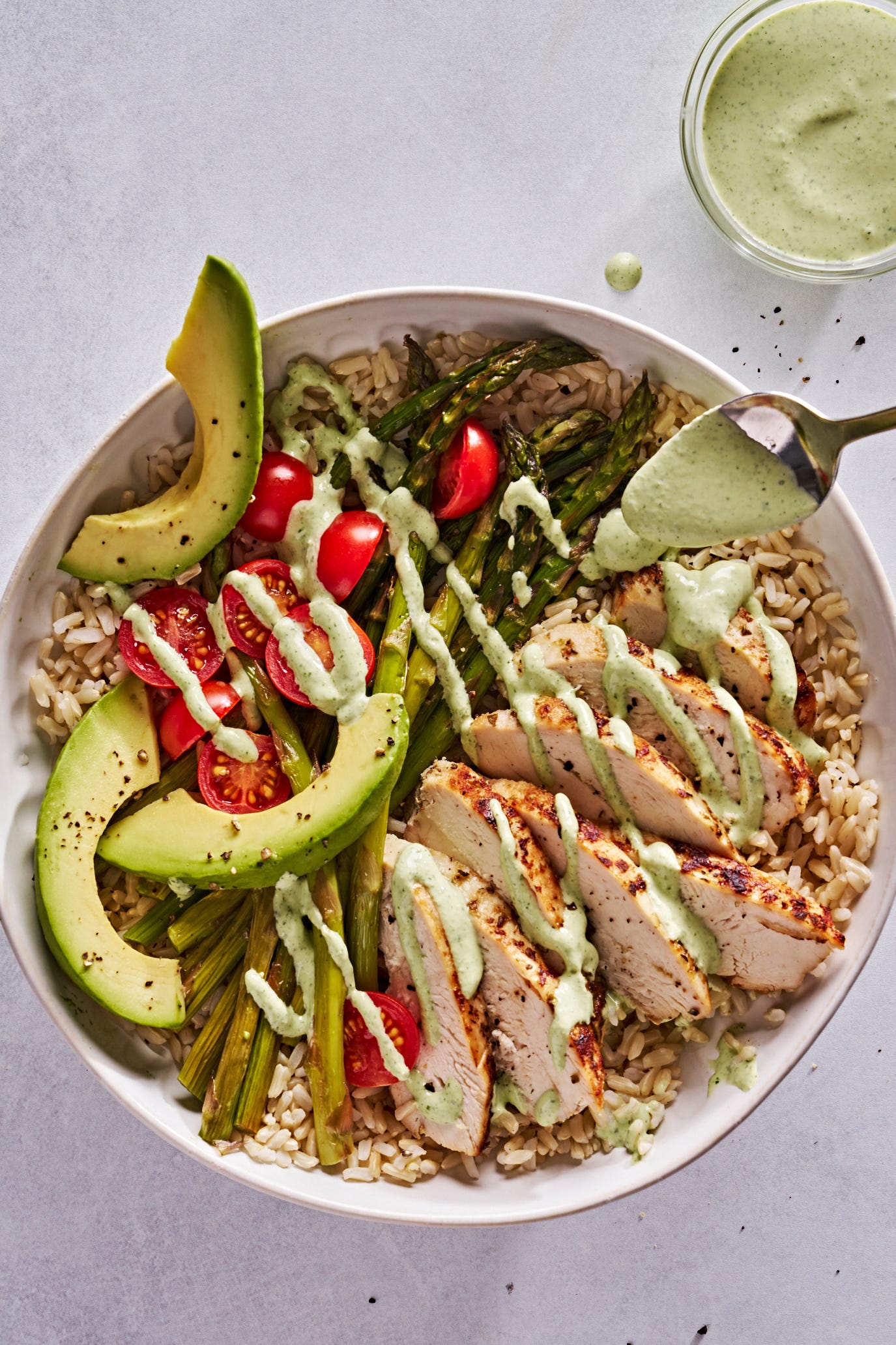 goddess bowls with chicken, asparagus, avocado and tomatoes drizzled with a creamy, green dressing