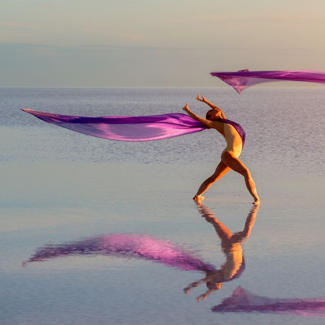 2 dancers on the beach with long purple flowing material