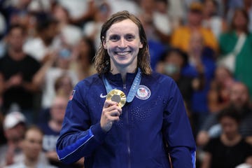 katie ledecky holds up a gold medal during olympic games in paris