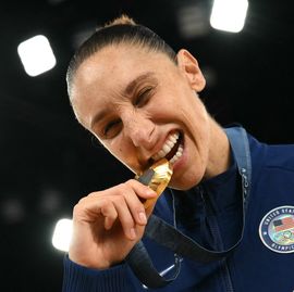 diana taurasi biting on an olympic medal