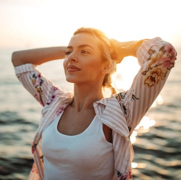 One with all that beauty around me young woman enjoying sunset by the sea