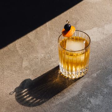 golden hour whiskey soda highball cocktail with ice, cherry orange peel garnish