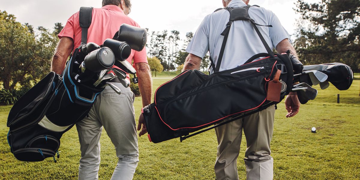 two men walking on course with golf bags