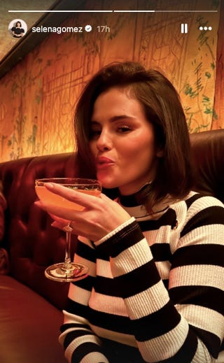 person holding a cocktail in a cozy setting