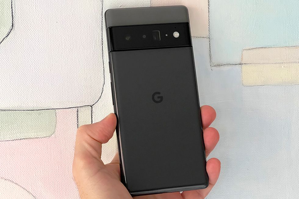 hand holding google pixel 6 pro in front of painting