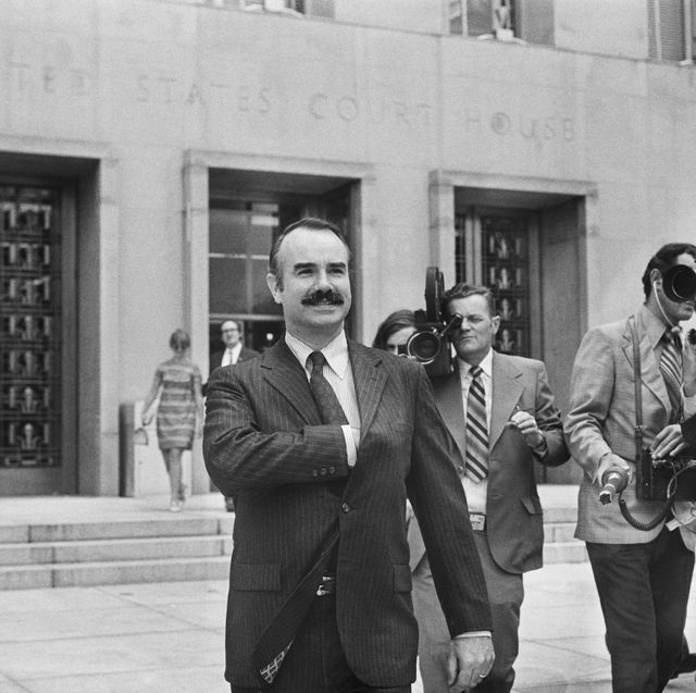 former white house aide g gordon liddy is filmed by journalists as he leaves u s district court, where he pleaded not guilty of breaking into democratic national headquarters at the watergate hotel
