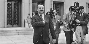 former white house aide g gordon liddy is filmed by journalists as he leaves u s district court, where he pleaded not guilty of breaking into democratic national headquarters at the watergate hotel