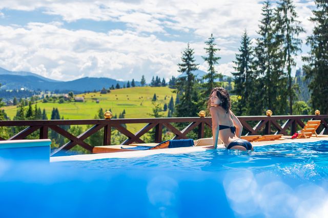 a gorgeous slim girl relax in the pool in hot summer day