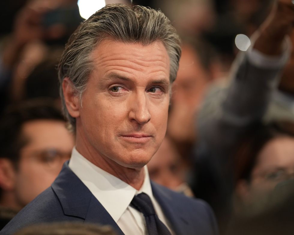 Gavin Newsom sitzt und dreht den Kopf nach rechts