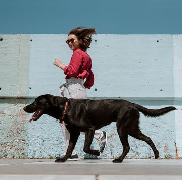 woman running alongside dog