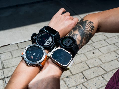 two arms are shown wearing three fitness watches