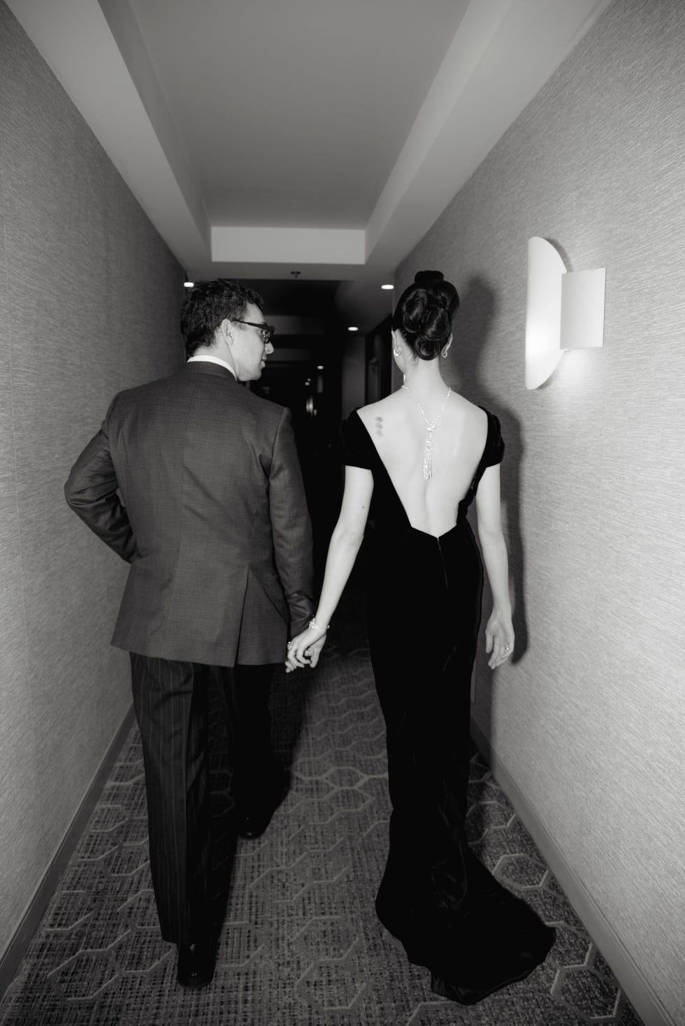 couple walking hand in hand down a hallway