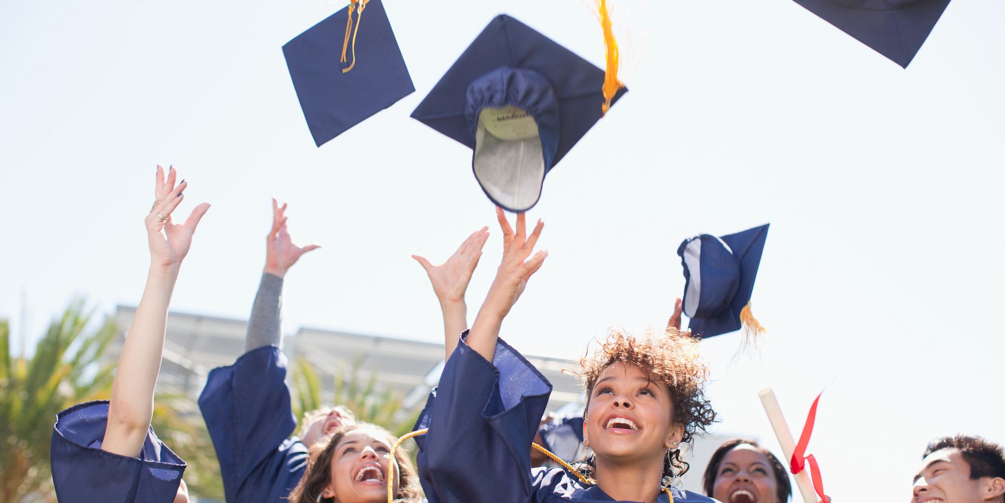 Graduates tossing caps into the air