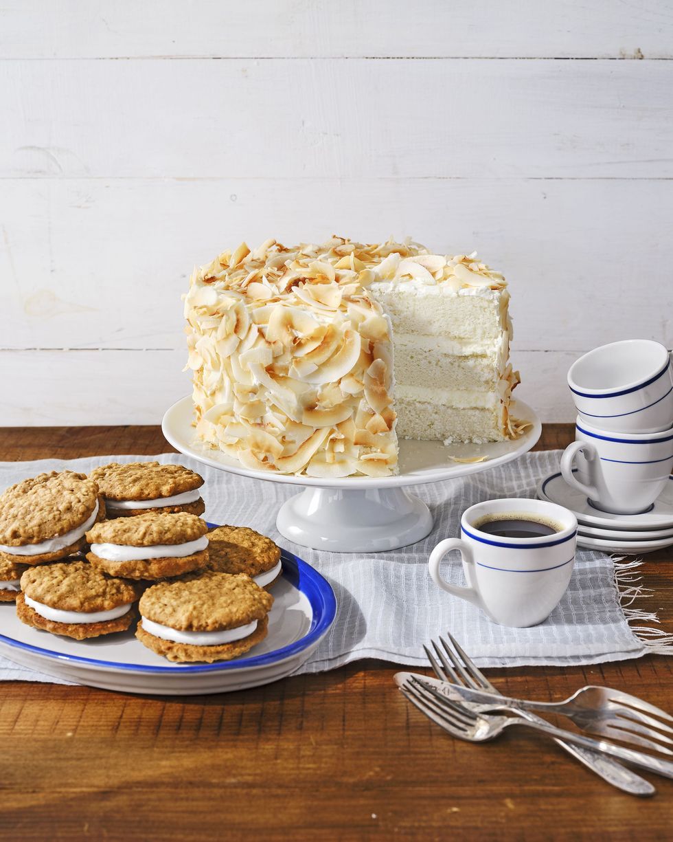 coconut angel cake on a white cake stand, homemade oatmeal cream pies, and coffee for a graduation party