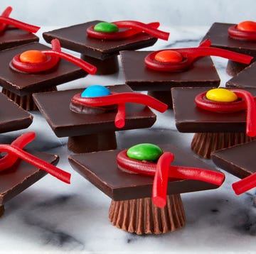 Graduation Caps rolos and reese's cups with chocolate bars stacked on top and candy to resemble graduation caps