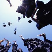 a graduation class throwing their caps into the air