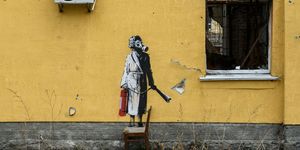 new graffiti by banksy on the wall of a destroyed residental buildings in the towns near kyiv