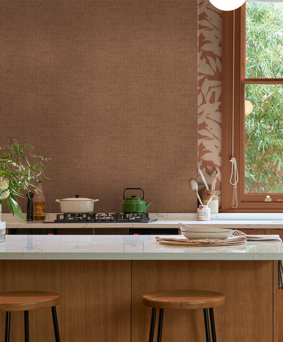 Wooden kitchen with textured wallpaper and a stripe with botanical print on the window