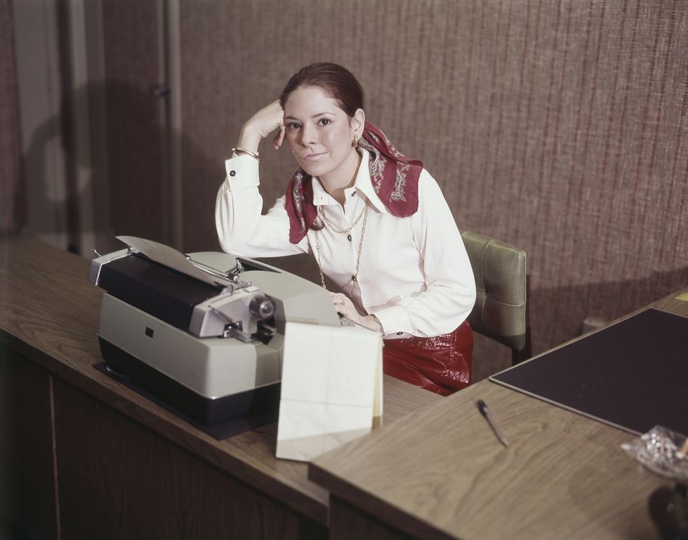 retrato de una joven junto a una máquina de escribir