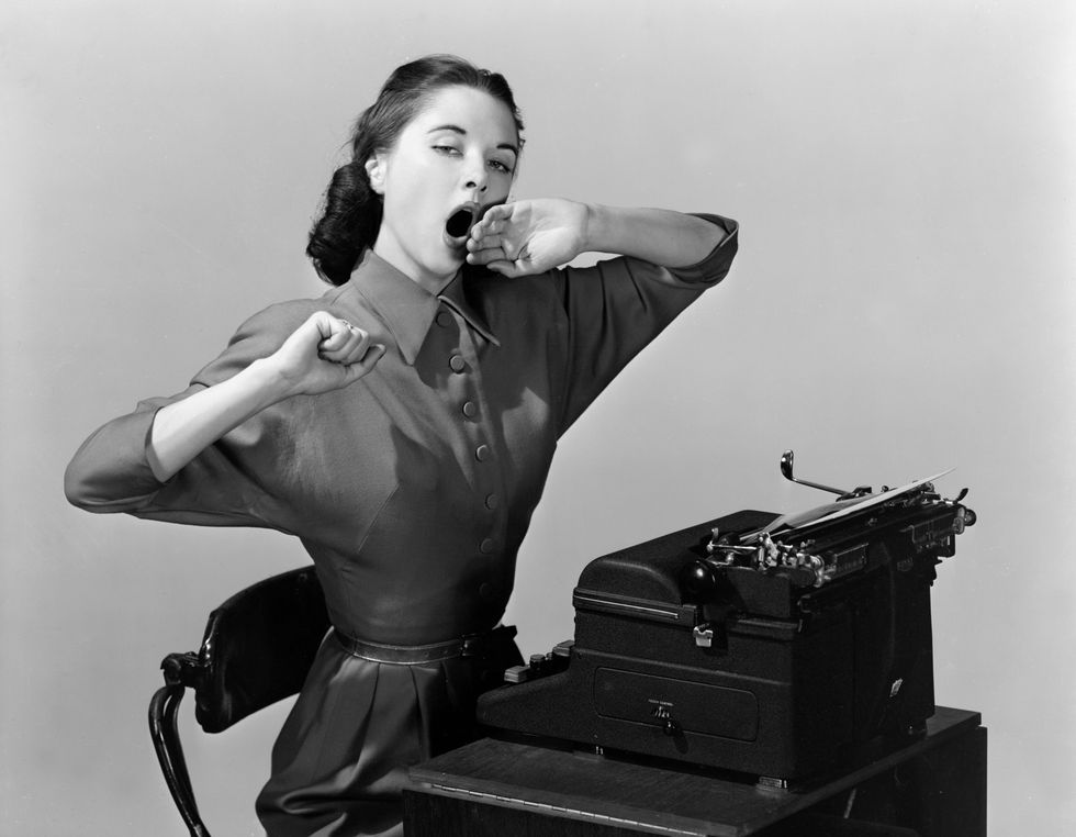 mujer bostezando ante una máquina de escribir 1956